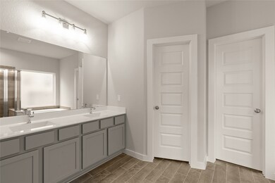 This primary bathroom is definitely move-in ready! Featuring a walk-in shower with tile surround, separate garden tub for soaking after a long day with custom tile detailing, dark stained cabinets with light countertops, spacious walk-in closet with shelving, high ceilings, custom paint, sleek and dark modern finishes.
