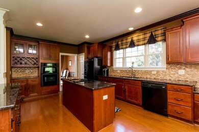 Spacious kitchen has granite countertops and beautiful cabinetry.