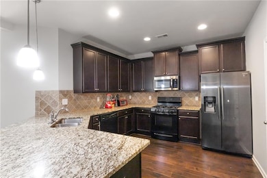 Kitchen featuring dark wood-type flooring, black a