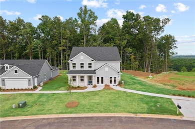 Traditional home featuring board and batten siding, a front lawn, and roof with shingles