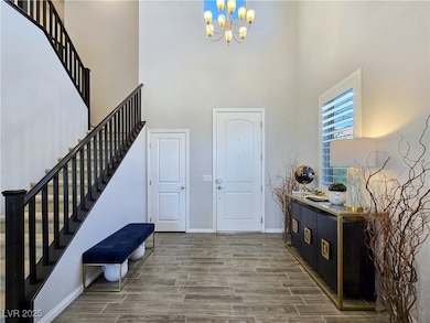 Foyer entrance with a high ceiling, stairs, a chan