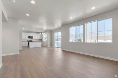 Unfurnished living room featuring recessed lighting, a chandelier, light wood-style flooring, and a textured ceiling