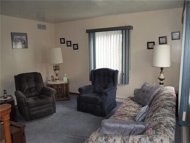 The living room features two windows and wall to w
