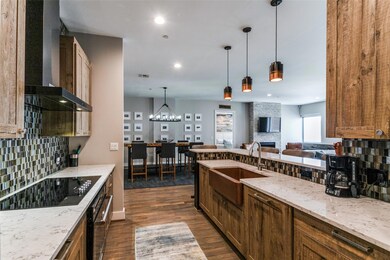 Kitchen with wall chimney range hood, sink, tastef