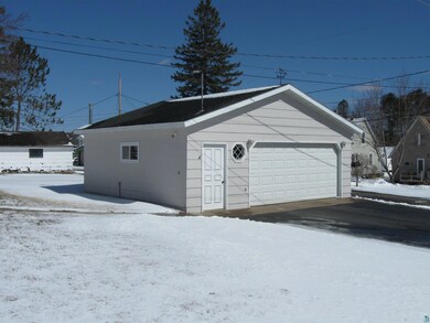 Snow covered garage featuring a detached garage