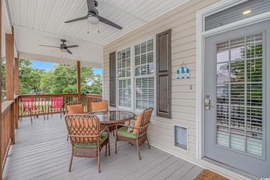 Wooden terrace with ceiling fan and outdoor dining area