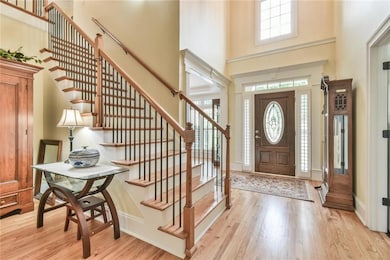Entryway featuring a towering ceiling, wood finished floors, and stairs