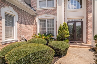 Property entrance with french doors, brick siding, and roof with shingles