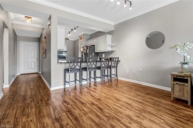 Kitchen with kitchen peninsula, track lighting, white cabinetry, and stainless steel fridge