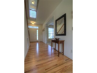 Two story foyer with beautiful hardwood floors.
