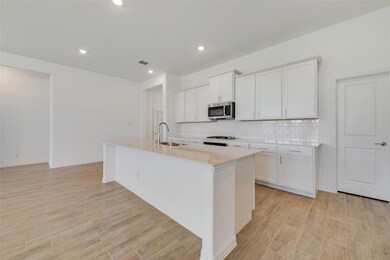 Kitchen featuring sink, a kitchen island with sink