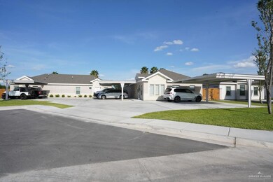 View of front facade featuring concrete driveway and a carport