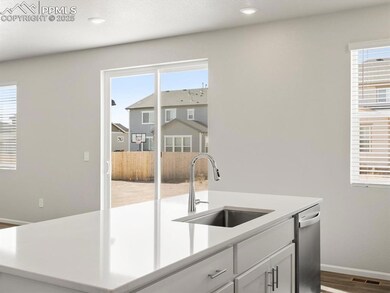 Kitchen with an island with sink, white cabinetry, plenty of natural light, and dark wood finished floors