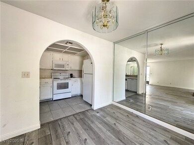 Kitchen with white appliances, a chandelier, wood