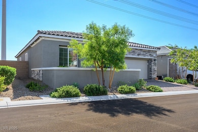 View of front of property featuring stone siding, stucco siding, driveway, and a tile roof