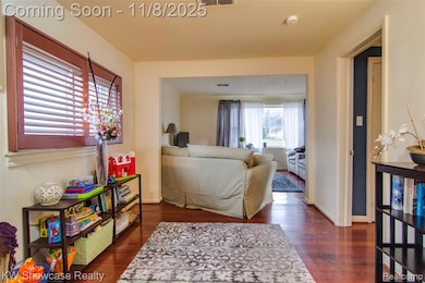 Living area featuring dark wood-style flooring and baseboards