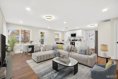 Living room with light wood-style floors and recessed lighting