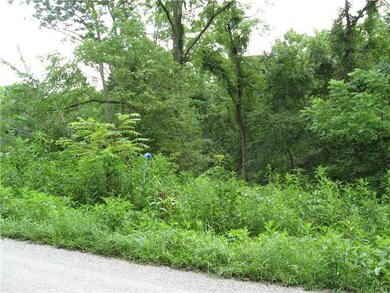 Exterior Front. Land slopes down from the road the