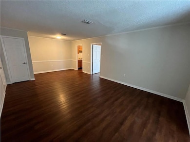 Spare room featuring a textured ceiling and dark h