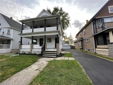 View of front facade featuring a front yard, garage, and a porch