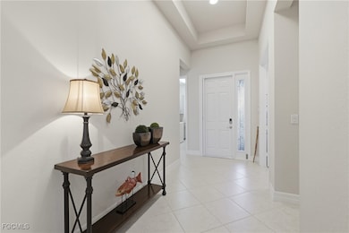 Foyer entrance featuring light tile patterned floors and a raised ceiling
