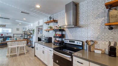 Kitchen stove and hood, looking into main living a