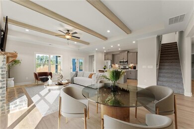 Living room featuring ceiling fan, beamed ceiling,