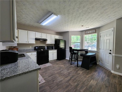 Kitchen with baseboards, light stone countertops, 