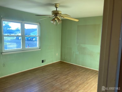 unfurnished bedroom with wood finished floors and a ceiling fan