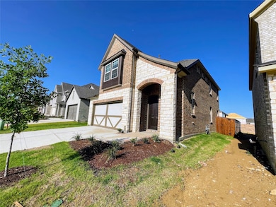 View of front facade with brick siding, driveway, stone siding, an attached garage, and a gate