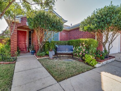 View of front of house with brick siding, a front yard, and an attached garage