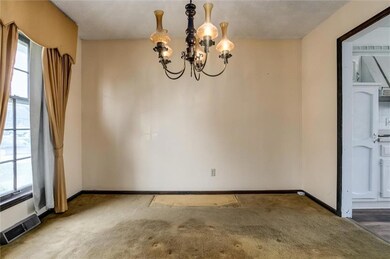Unfurnished formal dining room with large window, carpet flooring and a notable chandelier