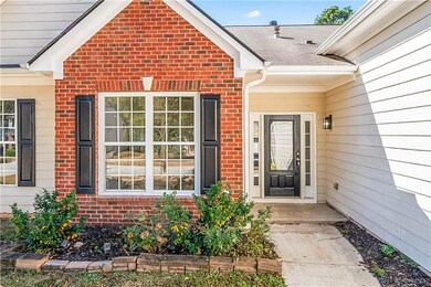 View of exterior entry with brick siding and roof with shingles