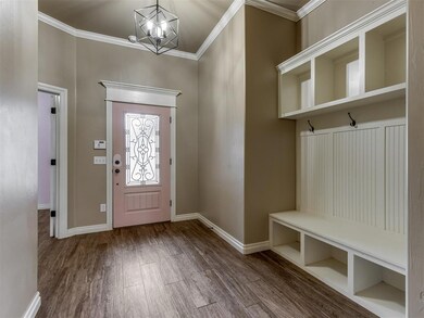 Foyer with wood-type flooring, a notable chandelie