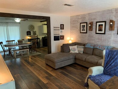 View of living room from entryway with new wood flooring and cedar trim going into dining room