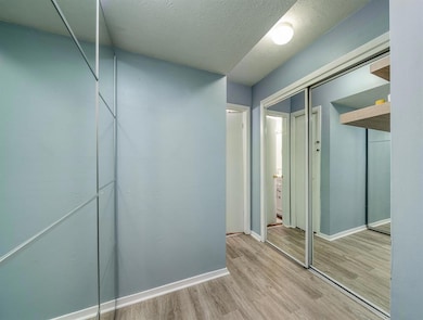 Corridor featuring a textured ceiling, wood finish