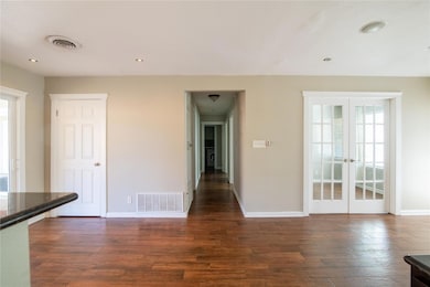 Unfurnished dining area featuring dark wood-style tile floors, french doors, recessed lighting