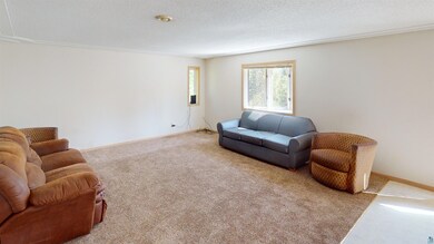 Living room with crown molding, a textured ceiling