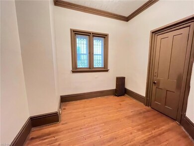 Unfurnished bedroom featuring crown molding and light hardwood flooring