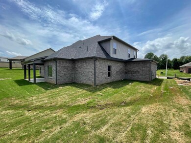 View of home's exterior featuring a yard, a shingled roof, and brick siding