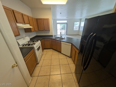 Kitchen featuring under cabinet range hood, white