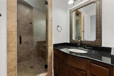 Bathroom featuring a textured wall, a shower stal