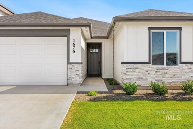 Ranch-style house featuring stone siding, an attached garage, a shingled roof, a front yard, and board and batten siding