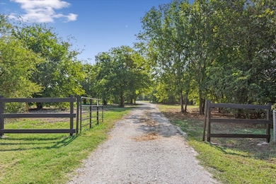 View of dirt / gravel road with a gate