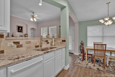 Kitchen with white dishwasher, light hardwood / wo
