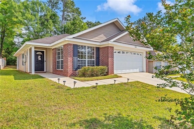 Ranch-style home with a garage, brick siding, a fr