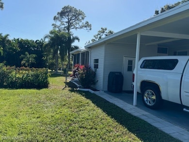 View of side of property with a carport and a yard