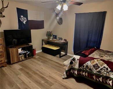 Bedroom with light wood-style flooring, ceiling fa