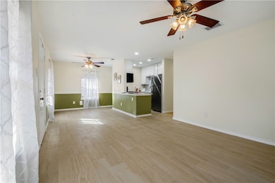 Unfurnished living room featuring a ceiling fan, light wood-style flooring, and recessed lighting
