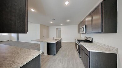 Kitchen with stainless steel appliances, light countertops, light wood finished floors, recessed lighting, and dark brown cabinets